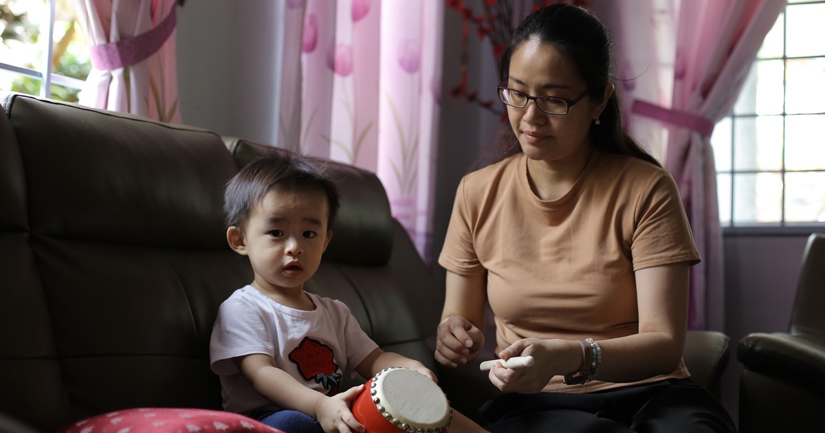 華人幼兒在媽媽陪伴下拿著小鼓探索聲音與節奏
