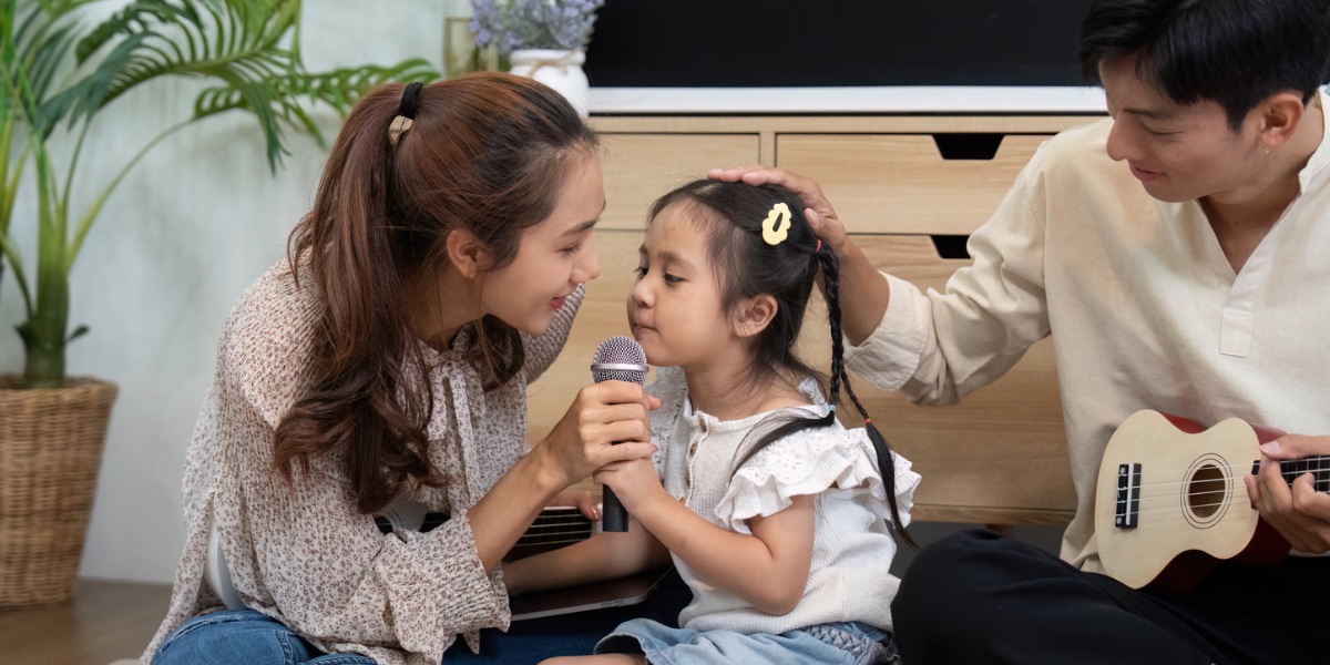孩子在台下怯怯地拉著家長、家長蹲下來理解他——比起催促，理解更能安定情緒
